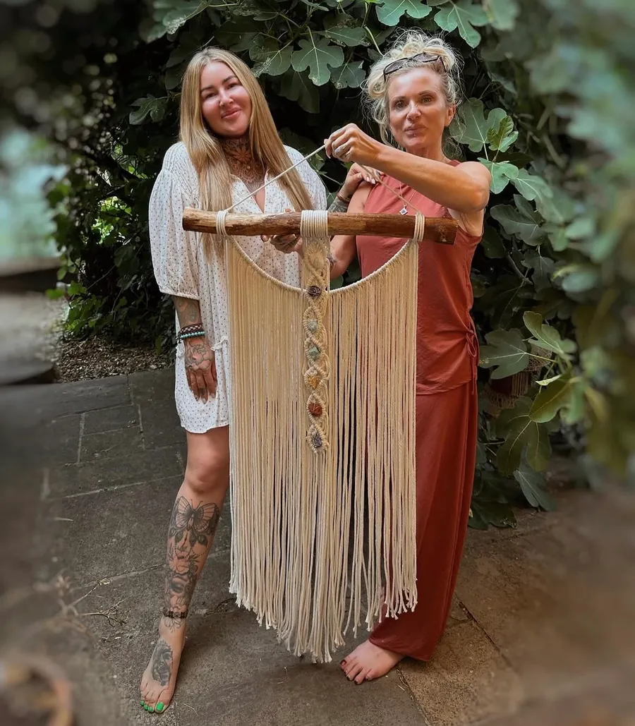 Lilijana and a guest holding a finished macrame wall hanging