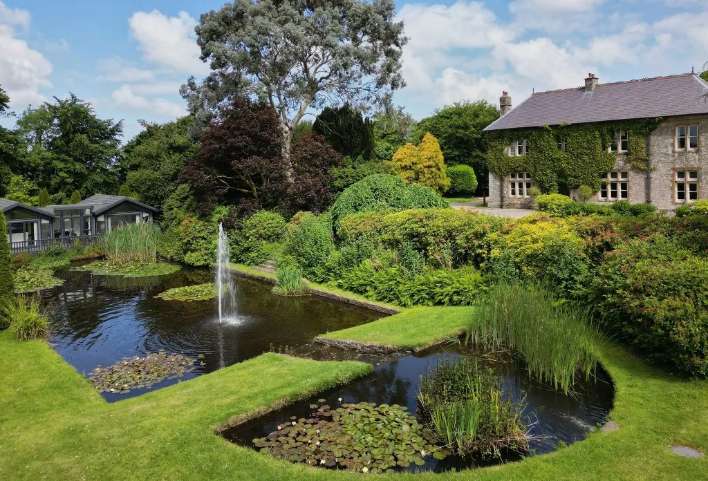 Kentisbury Grange estate grounds with ornamental pond and Victorian manor